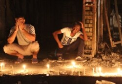 FILE - People light candles at the scene of a massive car bomb attack in Karradah, a busy shopping district, in the center of Baghdad, Iraq, July 3, 2016.