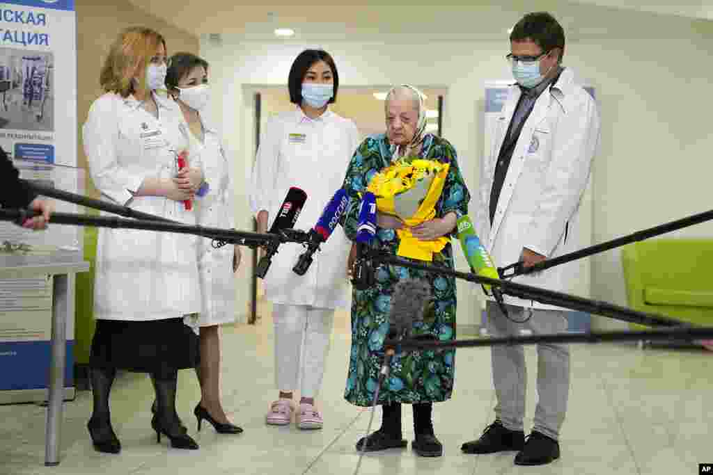 Patient Pelageya Poyarkova, 101, second from right, speaks with media as she leaves the recovery area for COVID-19 patients at the Federal Center for Brain and Neurotechnology in Moscow, Russia.