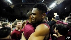 FILE - Harvard's Zena Edosomwan, right, celebrates with a teammate at the end of an NCAA college basketball game, March 14, 2015.