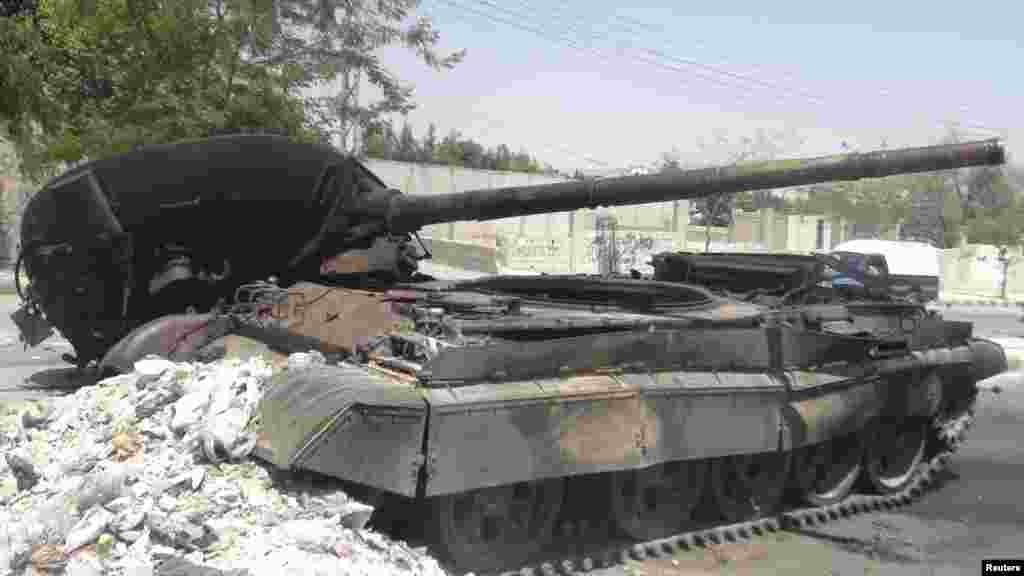 A destroyed Syrian army tank is seen in the Damascus suburb of al-Tel July 28, 2012.