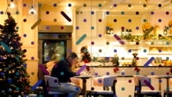 A man sits in a cafe in the area of Soho, in London, Dec. 16, 2021.