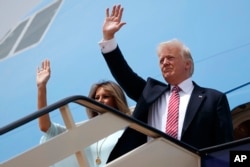 U.S. President Donald Trump, right, and first lady Melania Trump wave as they board Air Force One for Israel, the next stop in Trump's international tour, at King Khalid International Airport, May 22, 2017.