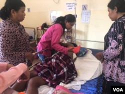 Family members attended to Pov Saroth, a construction worker who was shot by security forces over a land dispute in Sihanoukville province, Cambodia, January 27, 2019. (Sun Narin/VOA Khmer)