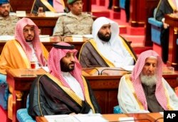 Photo provided by the Saudi Press Agency, SPA, Crown Prince Mohammed bin Salman (front left) seated next to the country’s most senior cleric, listens to Saudi King Salman give his annual policy speech in the ornate hall of the consultative Shura Council,