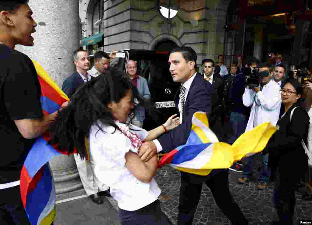 A hotel security staff (R) pushes back a Tibetan protester outside the Beijing 2022 Winter Olympic Candidate City presentation at the Palace hotel in Lausanne, Switzerland.