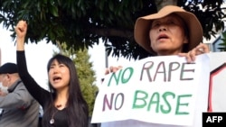 Civic group members shout slogans and hold placards as they attend a protest over the alleged rape of a local woman by two US servicemen in Okinawa, in front of the prime minister's official residence in Tokyo, Oct. 20, 2012.