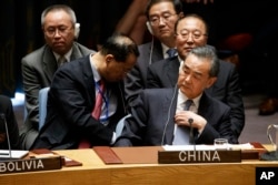 Chinese Foreign Minister Wang Yi listens as President Donald Trump speaks during a United Nations Security Council session, at U.N. headquarters in New York, Sept. 26, 2018.