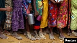 FILE _ Bare feet of Rohingya refugee children are pictured as they stand in a queue while waiting to receive food outside the distribution center in Palongkhali makeshift refugee camp in Cox's Bazar, Bangladesh, Nov. 7, 2017. 