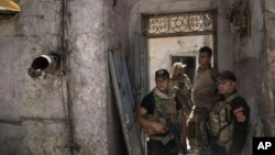 Iraqi special forces soldiers stand in a house retaken during fighting against Islamic State militants in the Old City of Mosul, Iraq, June 27, 2017. The Old City is the last IS stronghold in Mosul.