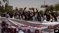 Protesters hold a banner calling for the release of political prisoners, during a march by members of the Sudanese medical profession syndicate, at the sit-in inside the Armed Forces Square, in Khartoum, Sudan, Wednesday, April 17, 2019. 