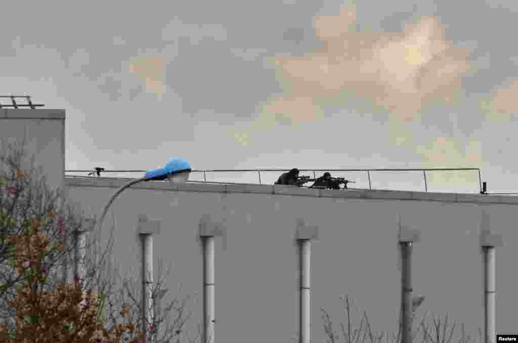 French sharp shooters take rooftop positions at scene of a hostage taking in an industrial zone in Dammartin-en-Goele, northeast of Paris, Jan. 9, 2015.