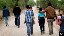 Sebuah keluarga migran Amerika Tengah berjalan dari wilayah Meksiko untuk menuju perbatasan AS dekat kota McAllen, Texas (foto: dok). 