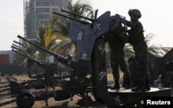 Philippine Marines check an anti-aircraft weapon mounted near the venues of the Asia-Pacific Economic Cooperation (APEC) summit during a security preparation in Manila, Nov. 14, 2015.