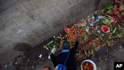 Pedro Hernández busca algo para comer o vender entre los alimentos descartados del mercado público de Coche en Caracas, Venezuela.