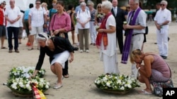 Relatives of victims of the Asian tsunami lay white roses on the beach during a commemoration and religious ceremony for German, Austrian and Swiss victims in Khao Lak, Thailand, Friday, Dec. 26, 2014. 