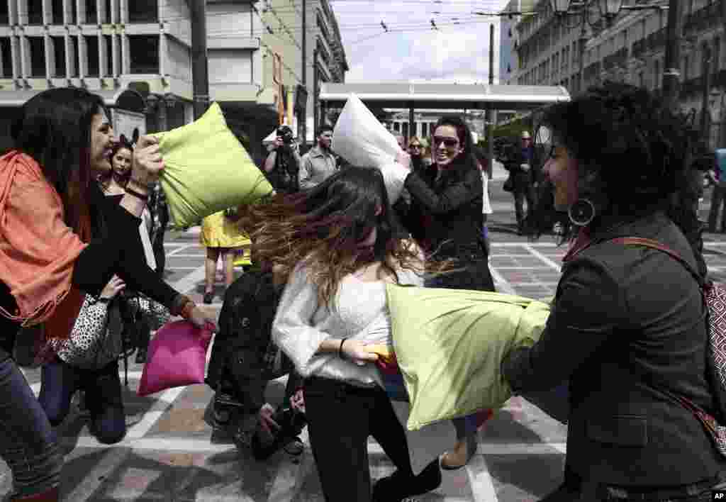 Youths participate in a pillow fight at a central square of Athens, Greece.