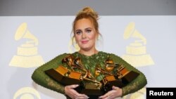 Muimbaji Adele akishikilia Grammys zake baada ya kushinda katika kundi la "Rekodi ya mwaka kwa wimbo wake "Hello" huko Los Angeles February 12, 2017