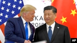 美国总统特朗普(左)在日本西部大阪举行的G20峰会期间与中国国家主席习近平握手（2019年6月29日）。