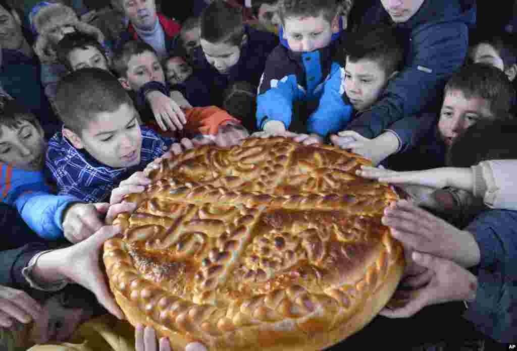 사라예보 인근 반자루카 마을에서 동방정교회 성탄절을 맞아 어린이들이 전통빵을 나누고 있다.