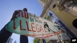 Immigration reform activists hold a sign in front of Freedom Tower in downtown Miami, Jan. 28, 2013.