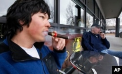 Jameson Florence, left, and Mark Jablonski as they smoke La Traviata cigars outside the Rain City Cigar shop in Seattle, 2011.