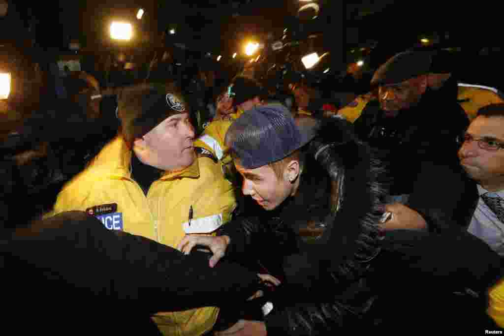 Ca sĩ nhạc pop Justin Bieber tới đồn cảnh sát ở Toronto, Canada, ngày 29 tháng 1, 2014. Đám đông người hâm mộ la hét và phóng viên bủa vây khi Bieber bước vào đồn cảnh sát Toronto hôm thứ Tư sau khi tin tức cho hay anh sẽ bị truy tố trong một vụ tấn công xảy ra ở thành phố này vào tháng 12 năm ngoái.