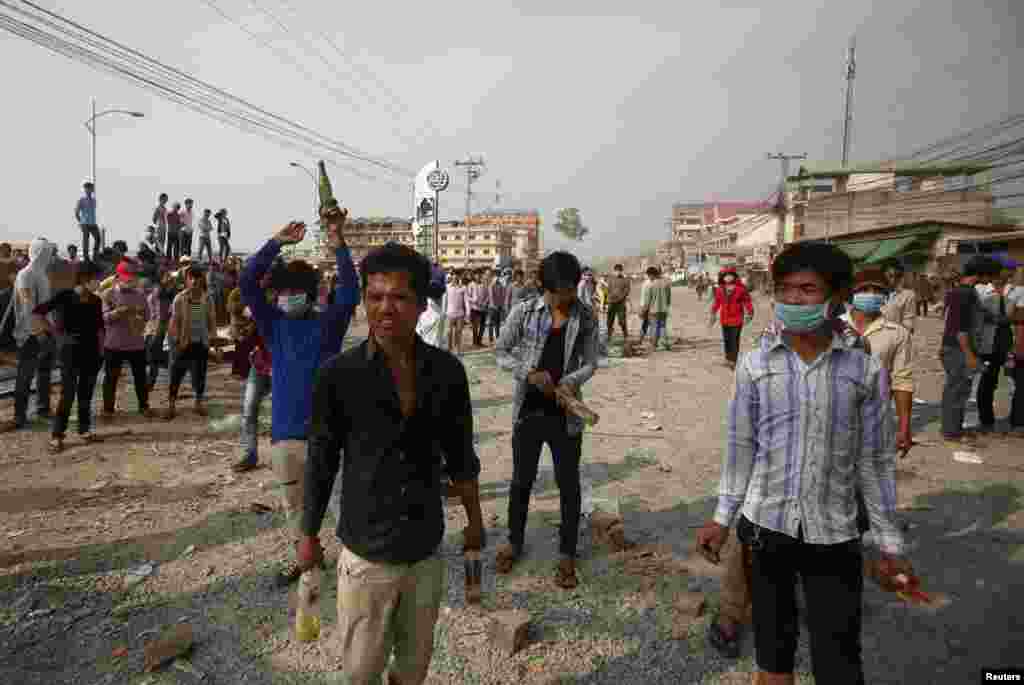 Garment workers hold gas bombs duing clashes with police in Phnom Penh, Jan. 3, 2014. 