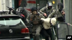 Salah Abdeslam emmené par des policiers lors d'un raid dans le quartier Molenbeek à Bruxelles, en Belgique, 18 Mars 2016. 