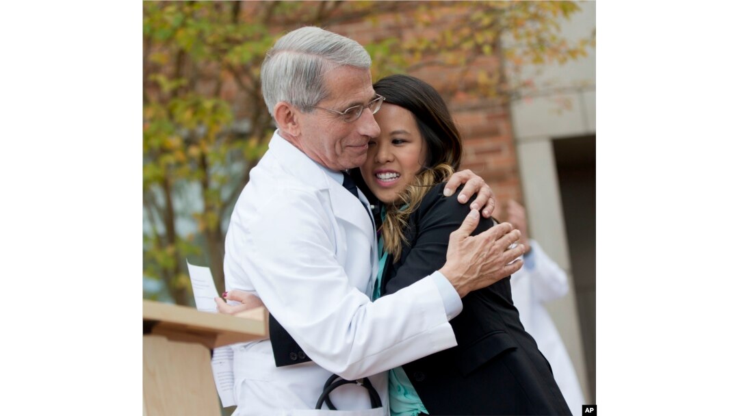 FILE - Dr. Anthony Fauci, head of NIH's National Institute of Allergy and Infectious Diseases, hugs Nina Pham as she's discharged from treatment in Bethesda, Maryland, Oct. 24, 2014.