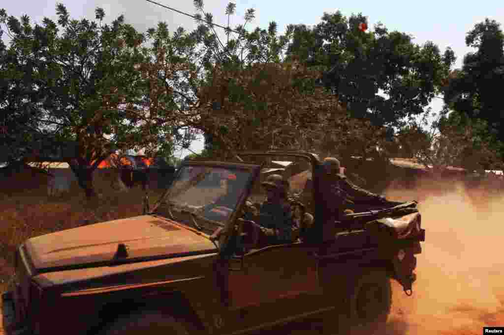 French soldiers drive past burning houses in Bossangoa, north of Bangui, Jan. 2, 2014. 