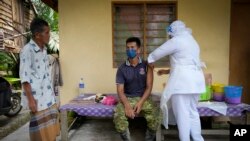 Nhân viên y tế tiêm vắc-xin ở Malaysia.