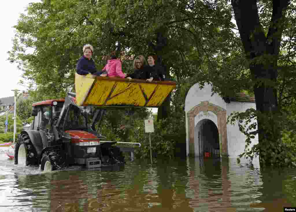 Residents are carried on a tractor in the eastern Bavarian village of Niederalteich, Germany, June 6, 2013. 