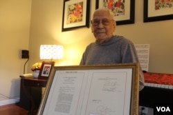 World War II veteran Celestino Almeda, 100, displays the documentation of his Congressional Gold Medal. He became a U.S. citizen in 1996. (I. Basco/VOA)