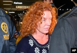 Tonya Couch is taken by authorities to a waiting car after arriving at Los Angeles International Airport, Dec. 31, 2015.