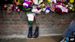 FILE - Military boots are displayed outside London's Woolwich Barracks in tribute to British soldier Lee Rigby killed nearby in May.