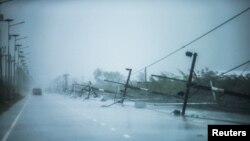 Fallen electricity poles are seen along a road as tropical storm Pabuk approaches the southern province of Nakhon Si Thammarat, Thailand, Jan. 4, 2019.