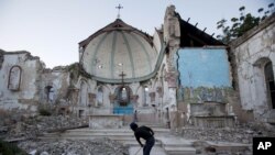 A man sweeps an area of the quake-damaged Santa Ana Catholic church in Port-au-Prince, Haiti, Jan. 12, 2013.