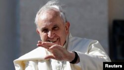 Pope Francis waves as he arrives to lead his Wednesday general audience in Saint Peter's Square at the Vatican, May 14, 2014. 