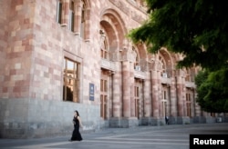 A woman walks in front of the government headquarters at the Republic Square in Yerevan, Armenia, May 3, 2018.