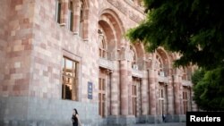 FILE - A woman walks in front of the government headquarters at the Republic Square in Yerevan, Armenia, May 3, 2018. The mayor of the Armenian capital resigned Monday.