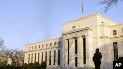 FILE - A guard stands outside the Federal Reserve Building in Washington, Jan. 14, 2010 