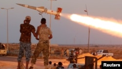 FILE - Fighters of Libyan forces allied with the U.N.-backed government fire a rocket at Islamic State fighters in Sirte, Libya, Aug. 4, 2016. 