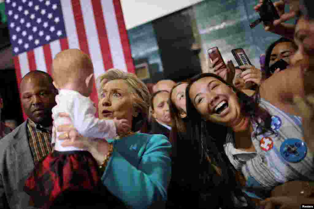 Democratic U.S. presidential nominee Hillary Clinton holds a baby during a campaign rally in Lake Worth, Florida.