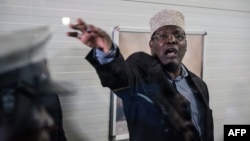 Kenyan opposition politician Miguna Miguna, who also holds Canadian citizenship and travels on a Canadian passport, reacts after Kenyan immigration authorities denied him entry into the country without a Kenyan visa, at Jomo Kenyatta International Airport