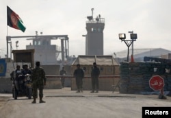 FILE - Afghan National Army (ANA) soldiers stand at the Bagram detainee centre gate north of Kabul, Feb. 13, 2014.