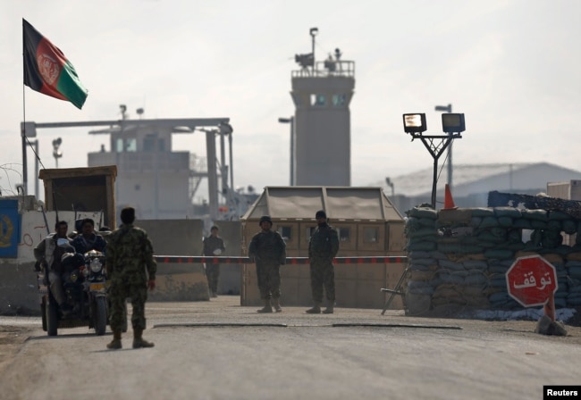 FILE - Afghan National Army (ANA) soldiers stand at the Bagram detainee centre gate north of Kabul, Feb. 13, 2014.