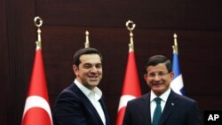 Greece's Prime Minister Alexis Tsipras (l) and his Turkish counterpart Ahmet Davutoglu shake hands after a joint news conference at Cankaya Palace in Ankara, Turkey, Nov. 18, 2015. 