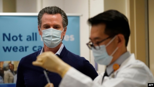 Gubernur Gavin Newsom menyaksikan vaksin Pfizer-BioNTech COVID-19 disiapkan oleh Direktur Farmasi Rawat Inap David Cheng di Kaiser Permanente Los Angeles Medical Center di Los Angeles, California pada 14 Desember 2020. (Foto: AFP)