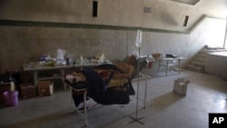  Mahmoud, 21, a Palestinian resident of Syria, rests in a field hospital after he was found Monday, August 6, 2012, with three gunshot wounds on the outskirts of Aleppo, Syria.