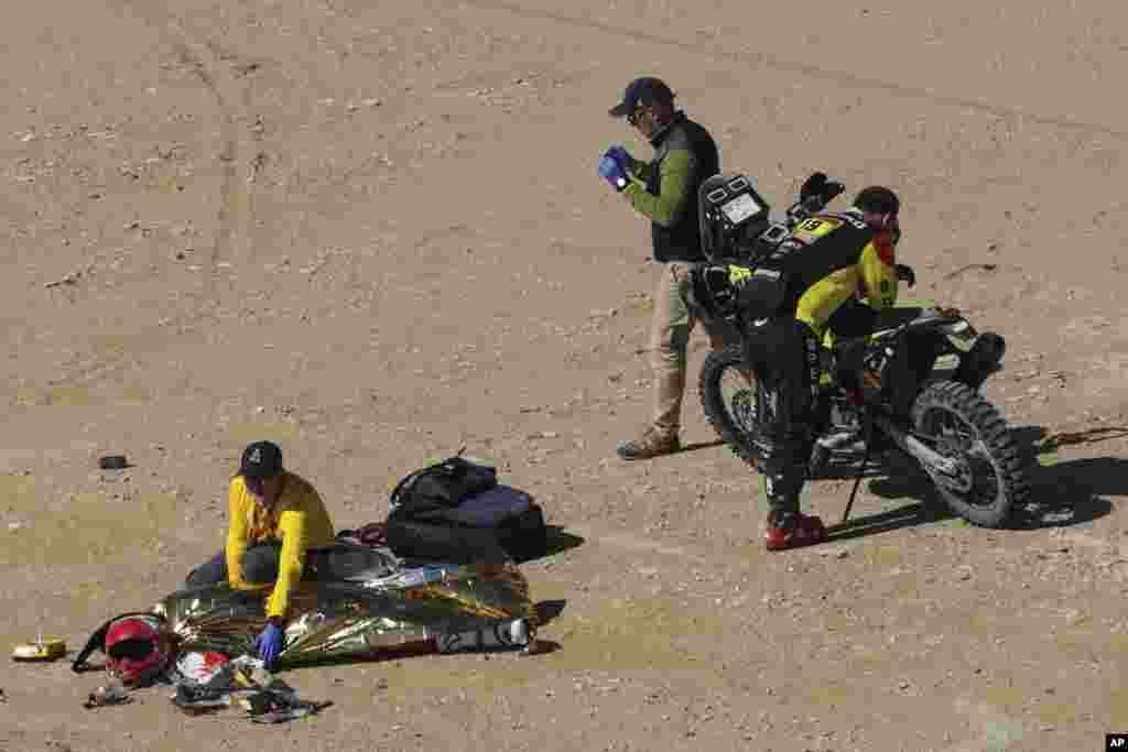 The body of Paulo Gonçalves of Portugal is covered with a blanket after a deadly fall during stage seven of the Dakar Rally between Riyadh and Wadi Al Dawasir, Saudi Arabia.